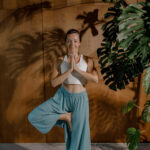 Девушка выполняет балансовую асану в йоге - Врикшасану, позу "дерева"